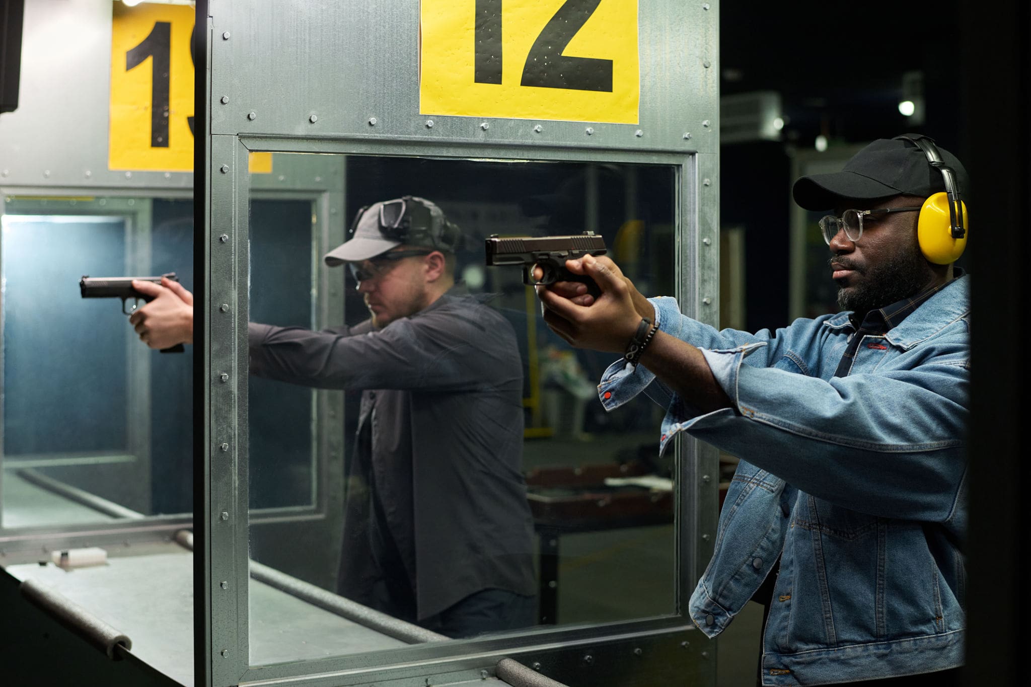 Indoor shooting range with two participants.