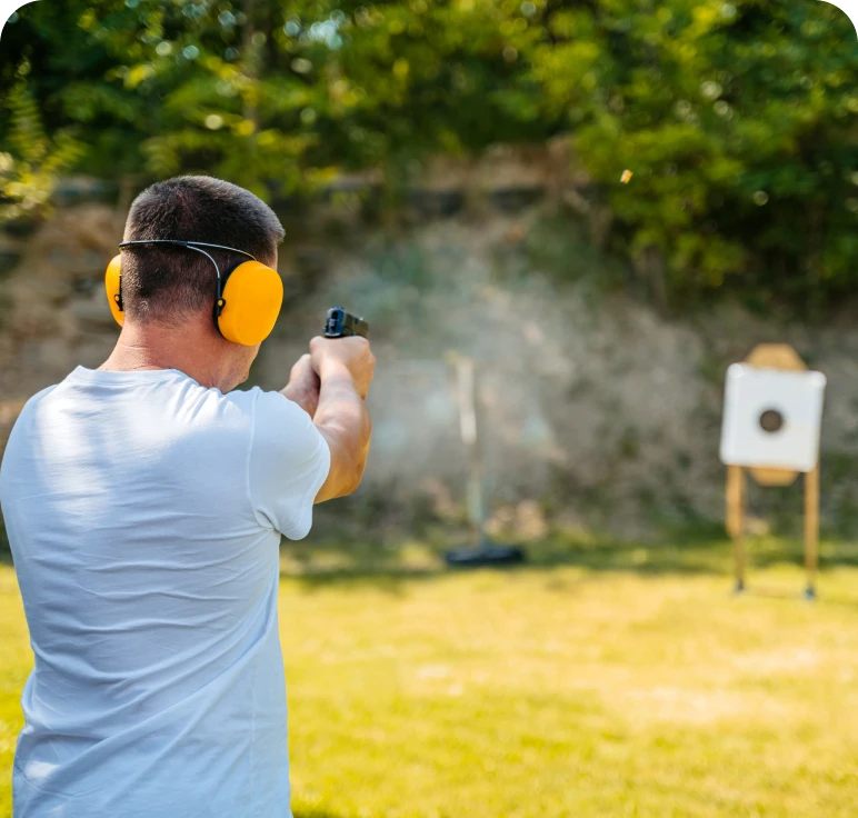 Individual with earmuffs shooting at target